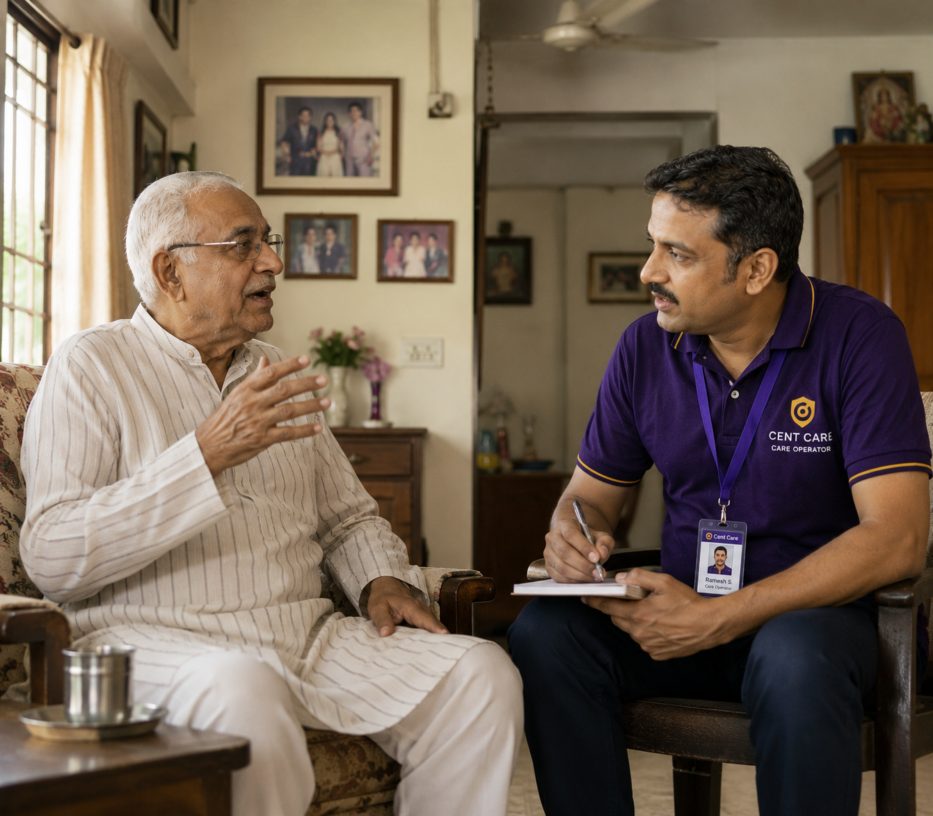 An elderly Indian man in conversation with a Cent Care operator in his living room